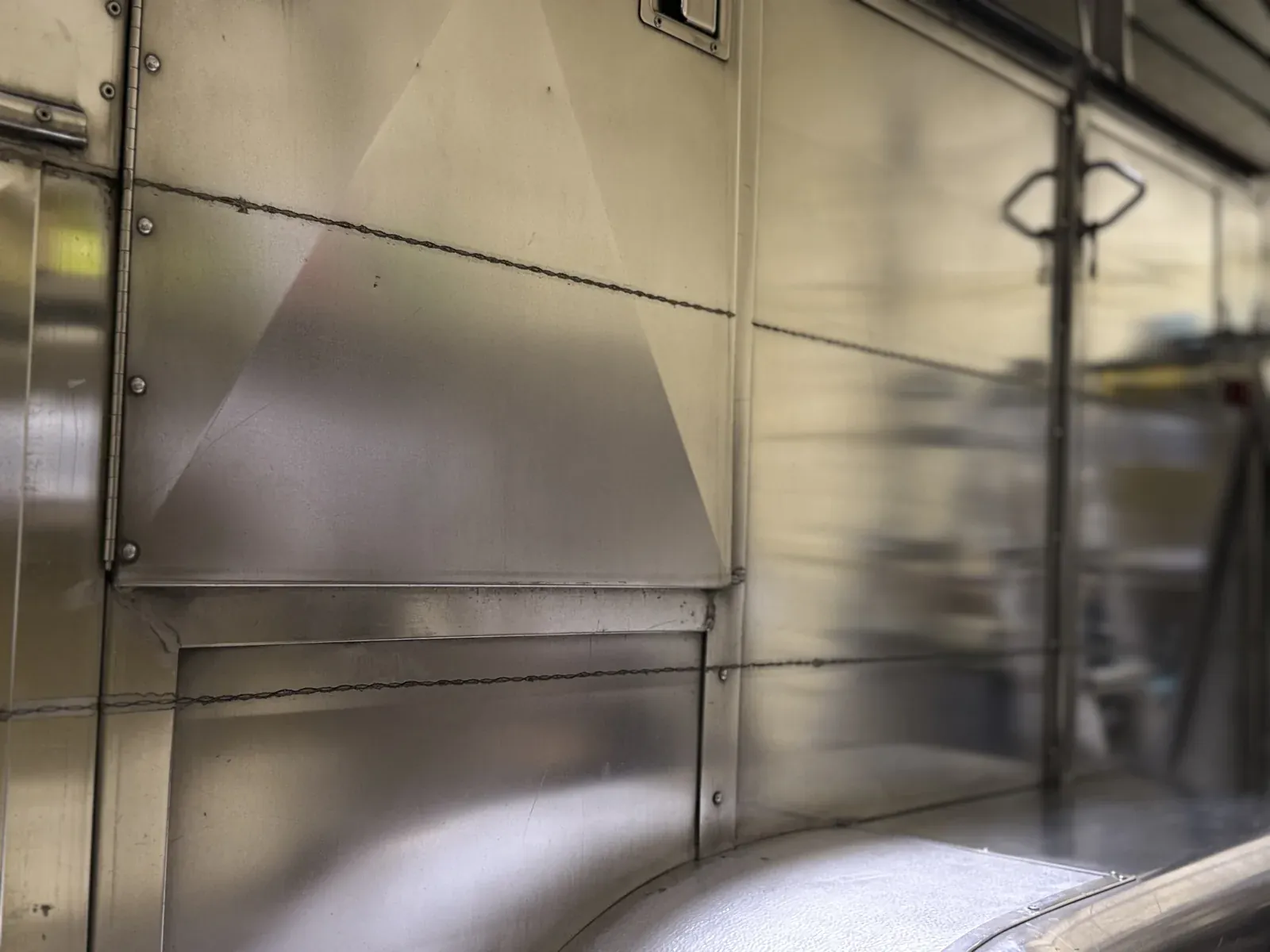 Close-up of polished aluminum trailer panels with sharp reflections