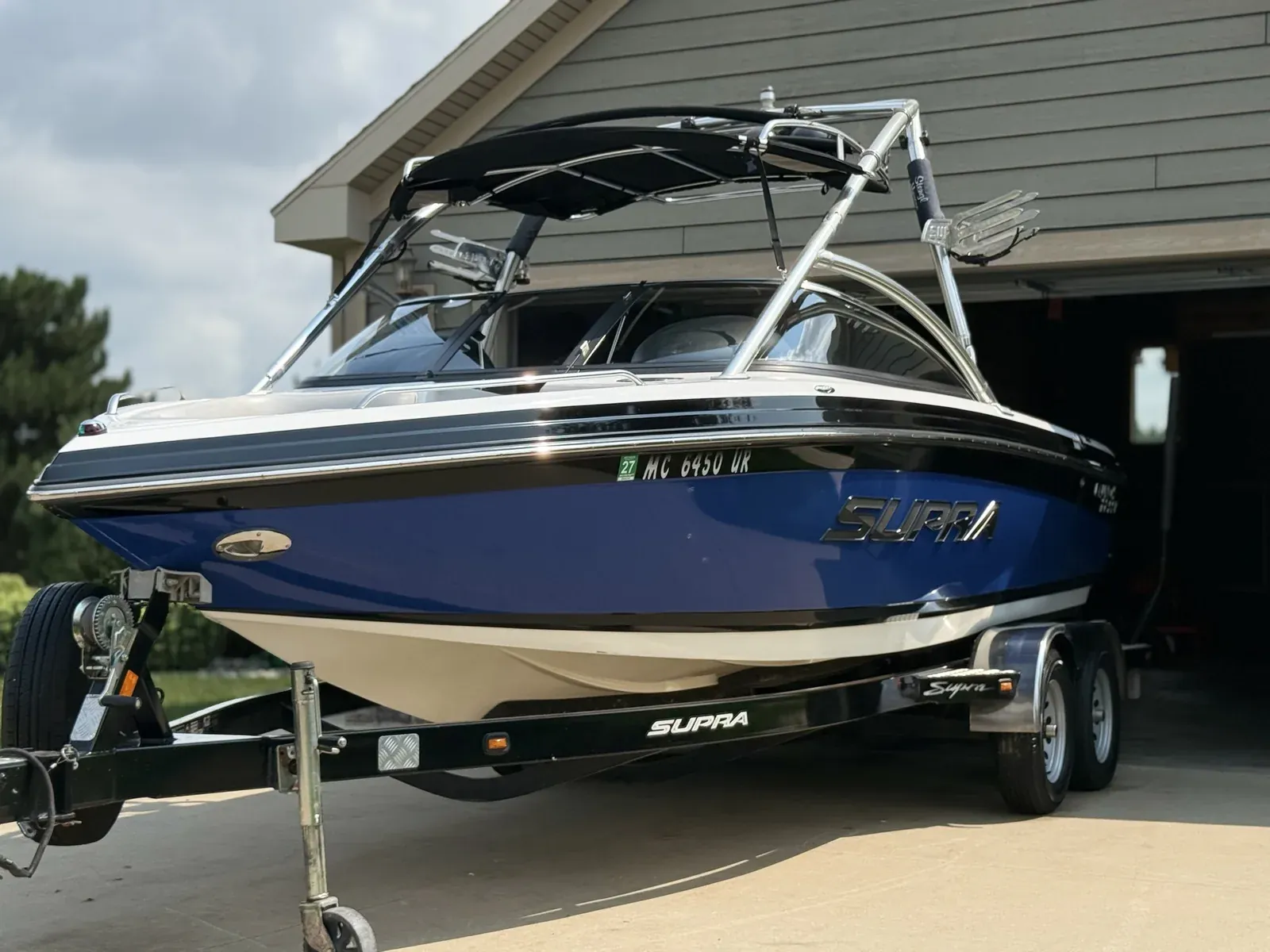 Blue and white Supra wakeboard boat on its trailer after detailing