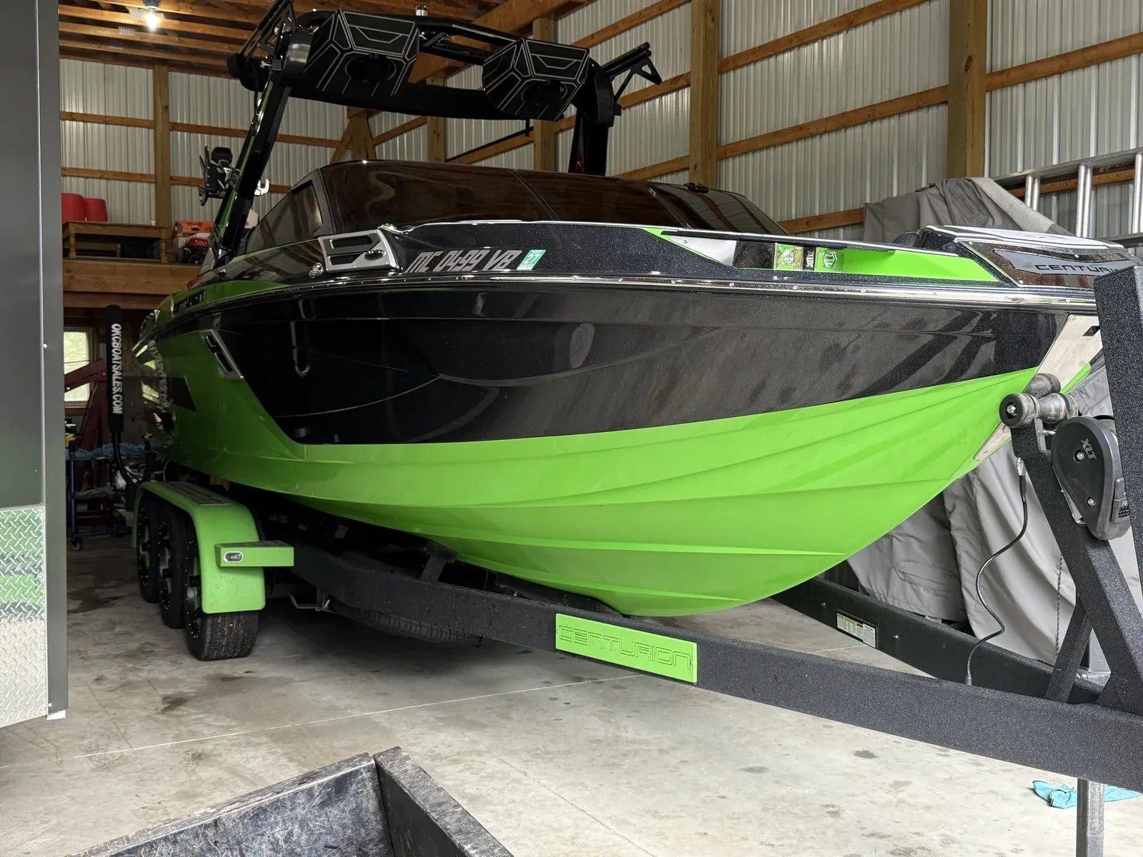 Green and black Centurion wake boat on its trailer after a full detail