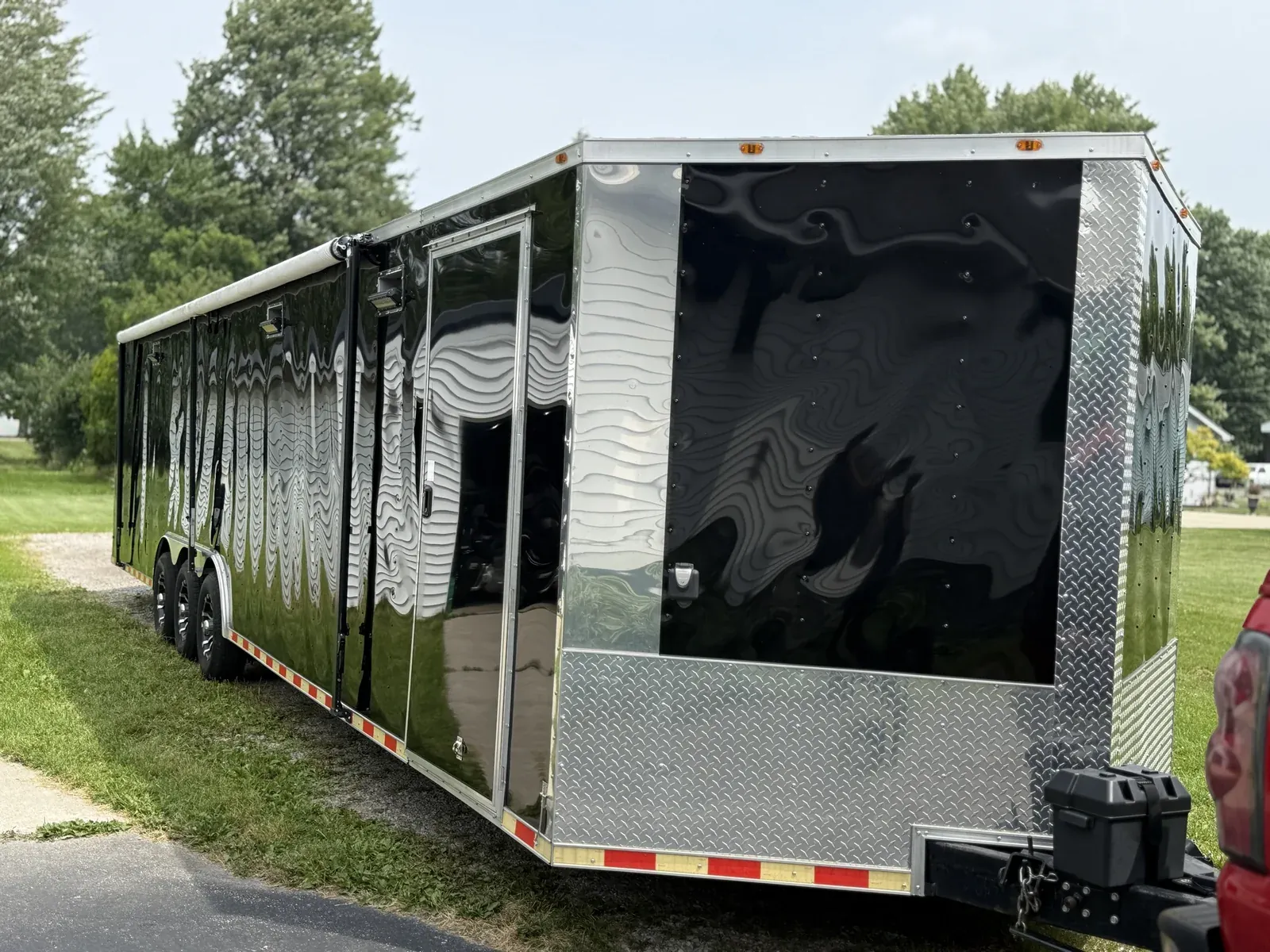 Black enclosed car trailer with mirror-like gloss after exterior detailing