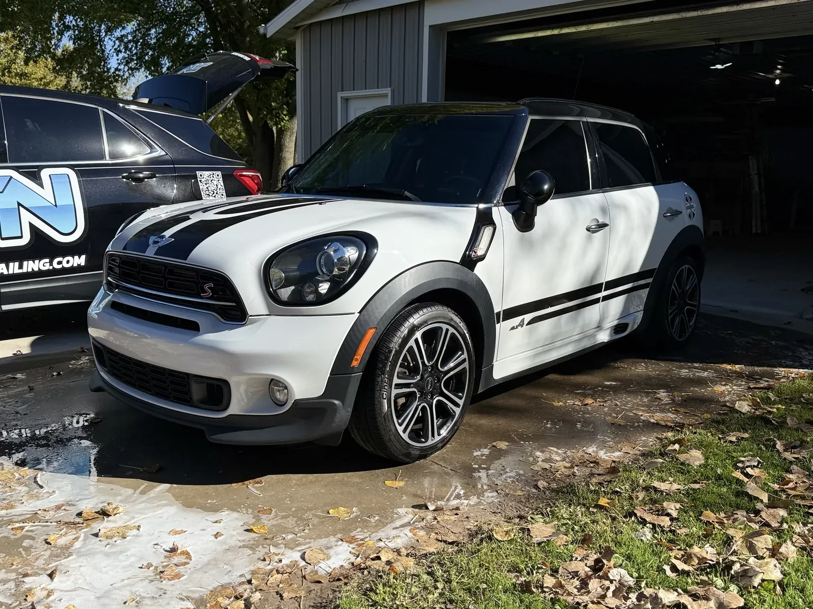 White Mini Cooper Countryman after a mobile detail, parked next to a JTN Mobile Detailing branded Chevy Equinox