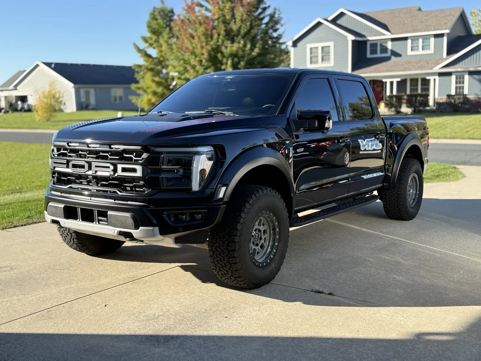 Black Ford F-150 Raptor detailed in a customer's driveway